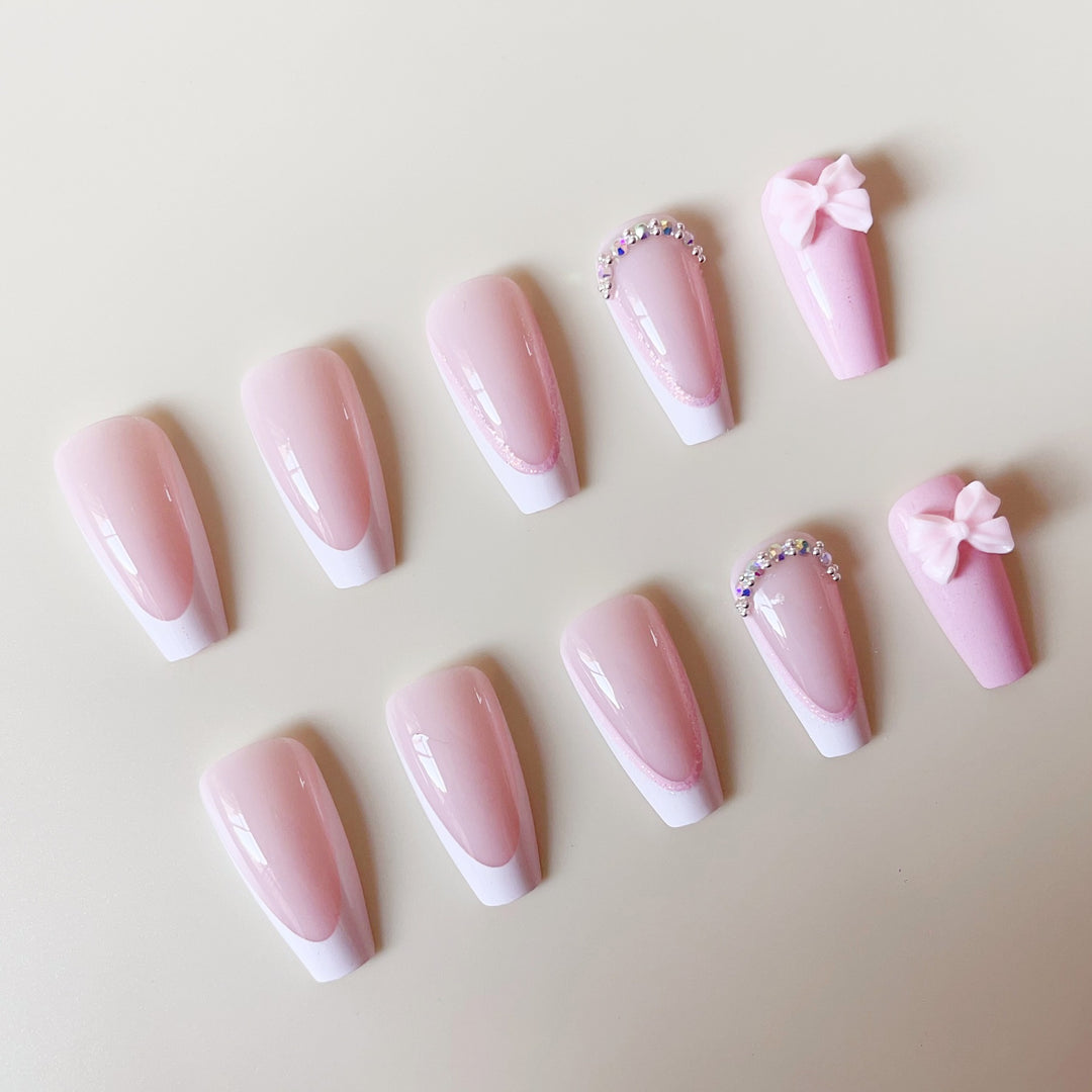 Artificial nail set with playful bows and glitter accents Bowlift