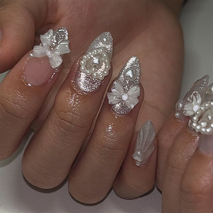 Artful nail decoration with pearl and bow accents Bowlift