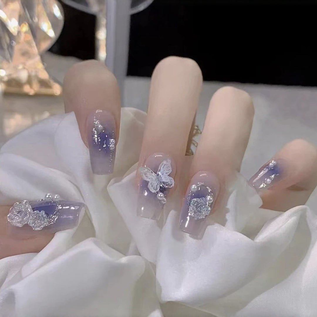 Artistic acrylic nails with butterfly design and glitter accents Bowlift