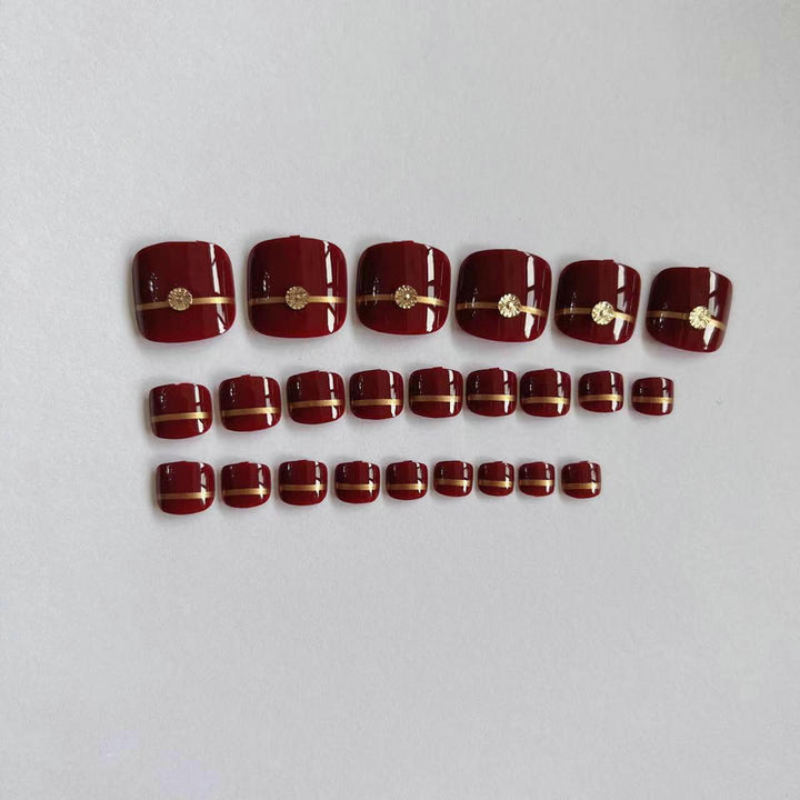 Artificial toenails with elegant gold embellishments Bowlift