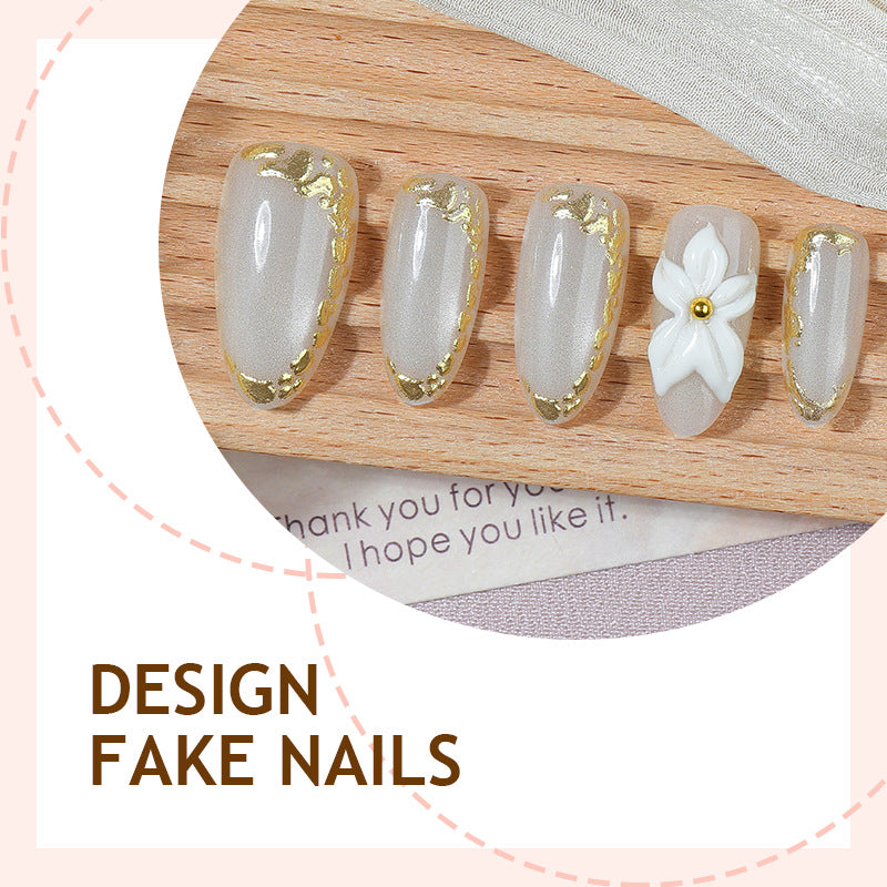 Acrylic nail set with elegant gold embellishments and floral accent Bowlift