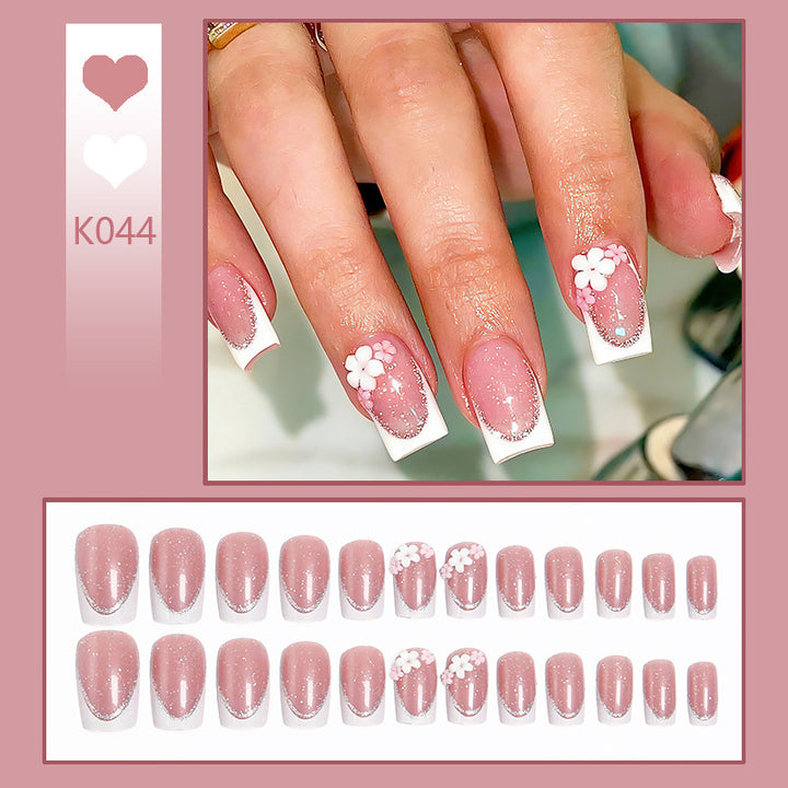 Acrylic nail set with elegant French tip and delicate floral decorations Bowlift