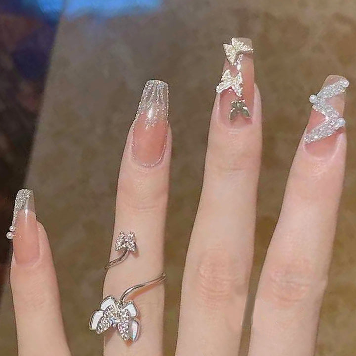 Artificial nails with sparkling rhinestone and bow accents Bowlift