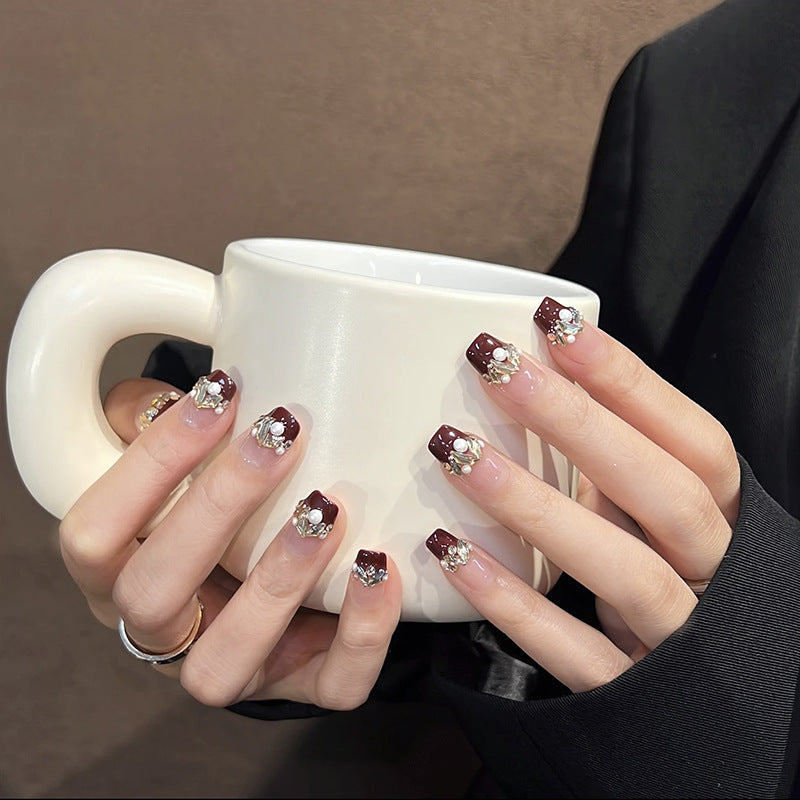 Glamorous artificial nails with decorative pearl and glitter embellishments Bowlift