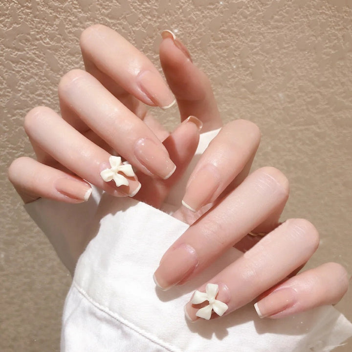 Artificial nails with elegant bow accents and pearl decorations Bowlift