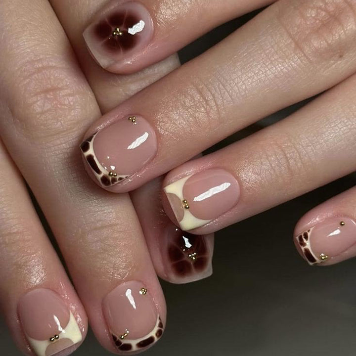 Artful nail extensions with an elegant giraffe pattern and golden accents Bowlift