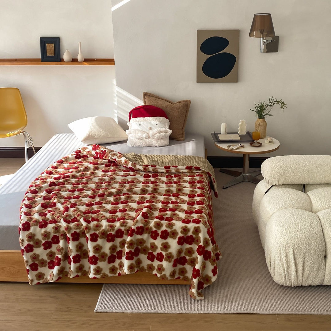 Patterned throw blanket with woven flower appliqués