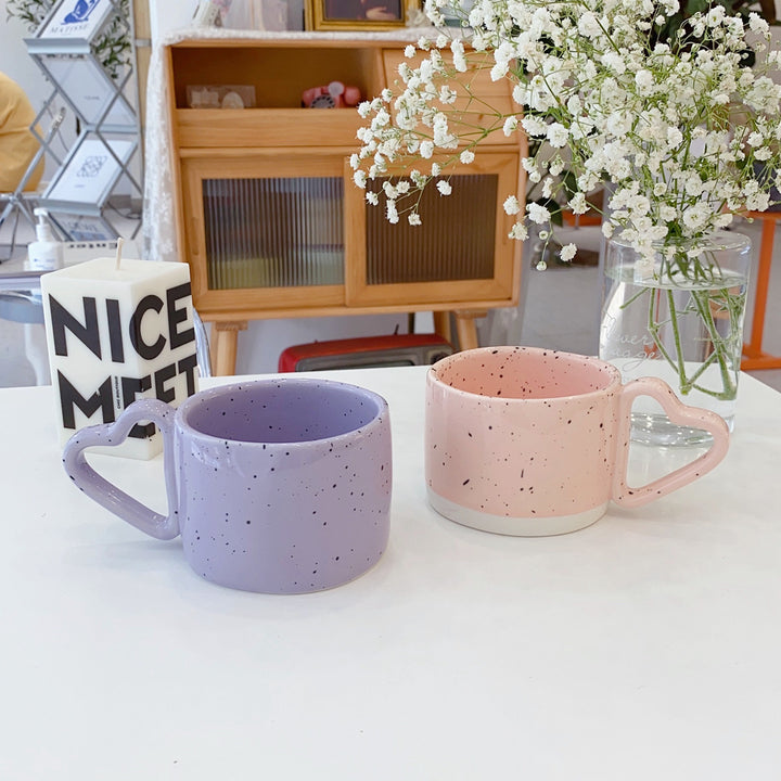 Ceramic mug with heart-shaped handle and speckle design