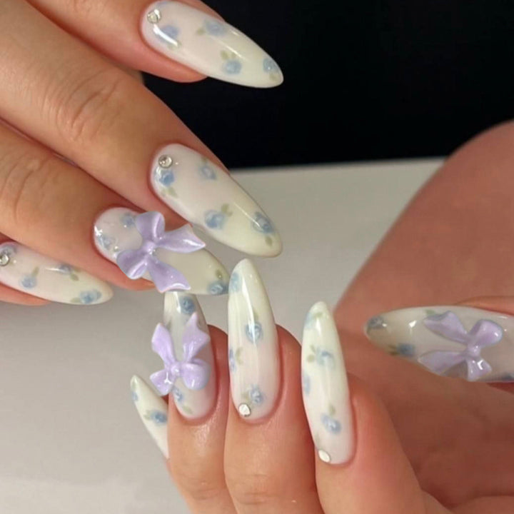 Artful stiletto nails with delicate flower patterns and glitter accents Bowlift
