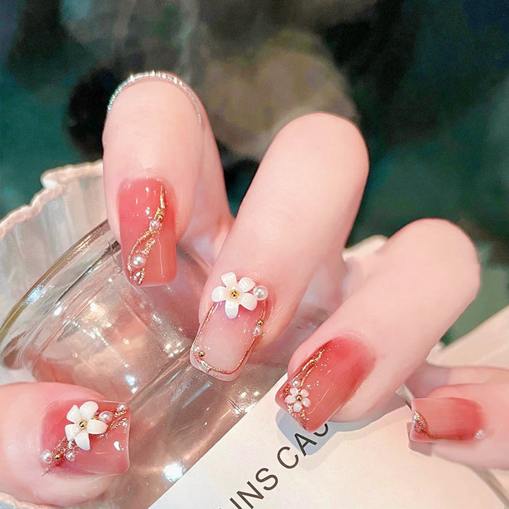 Acrylic nail set with elegant floral decorations and glamorous pearl accents Bowlift