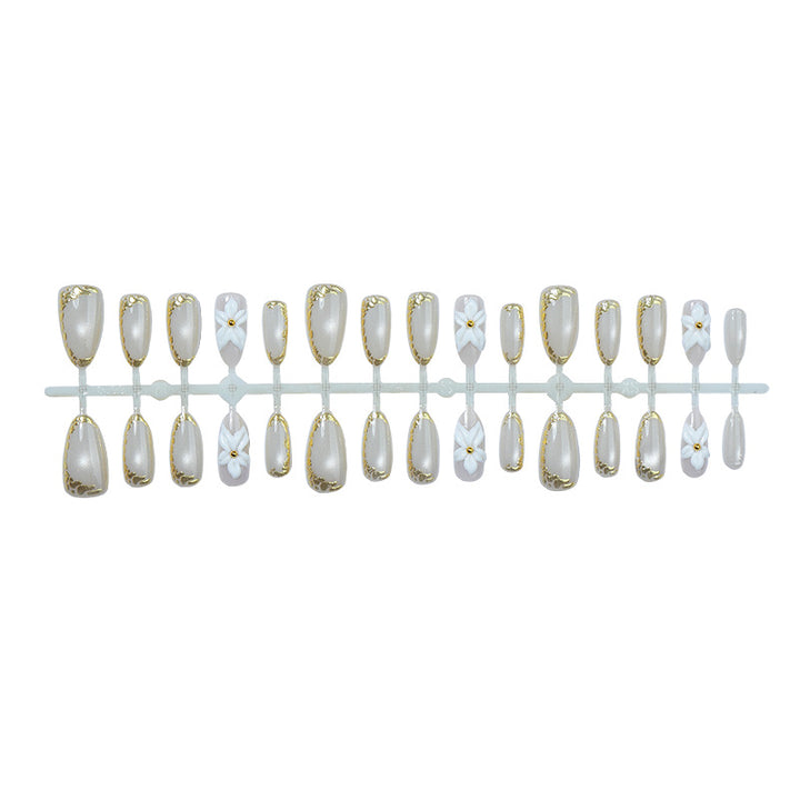 Acrylic nail set with elegant gold embellishments and floral accent Bowlift
