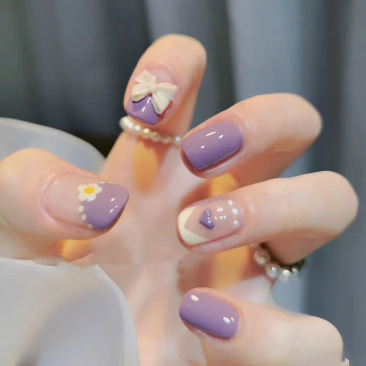 Glamorous artificial nails with heart design and glittering accents Bowlift