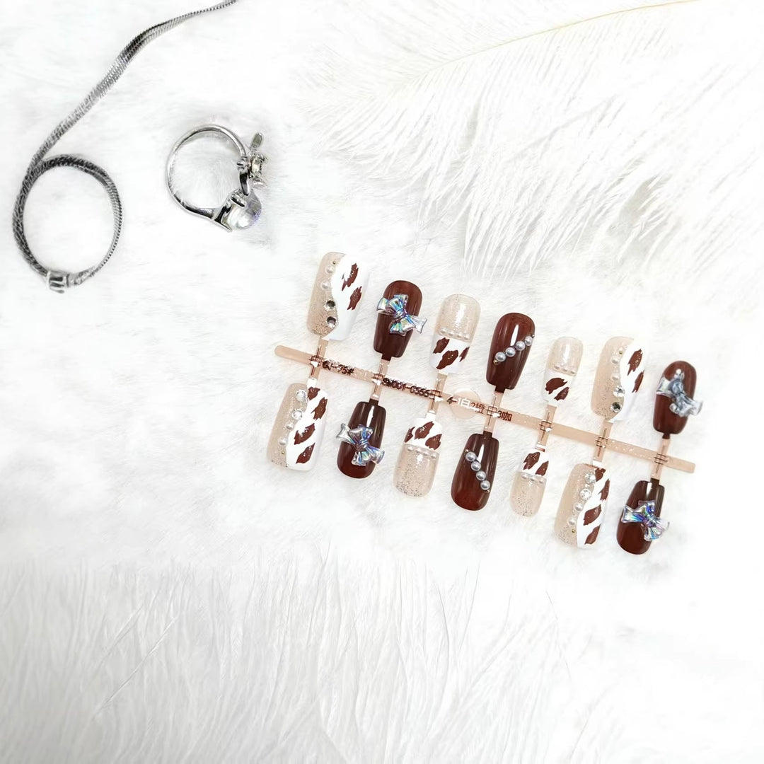 Artificial nails with sparkling rhinestone and bow accents Bowlift