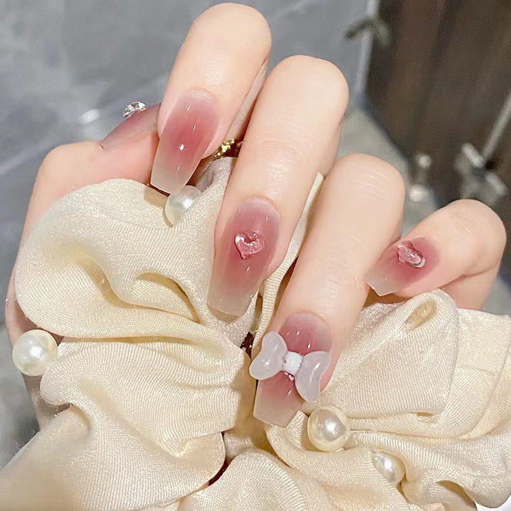 Artful acrylic nails with heart and bow design Bowlift
