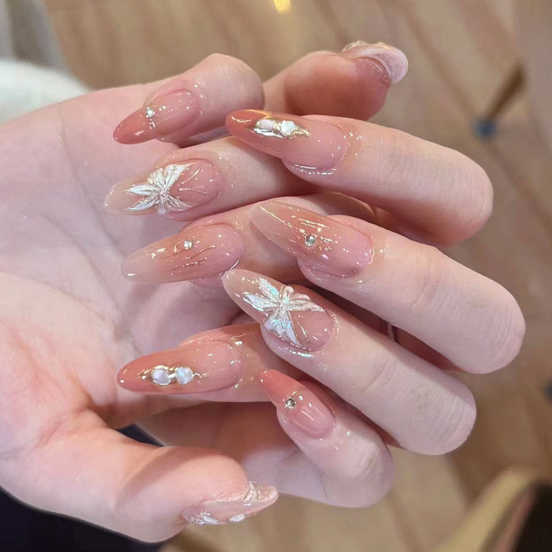 Artificial nail extensions with floral motifs and glitter accents Bowlift
