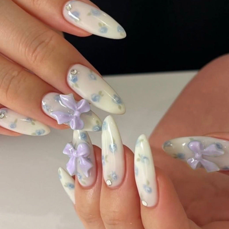 Artful stiletto nails with delicate flower patterns and glitter accents Bowlift