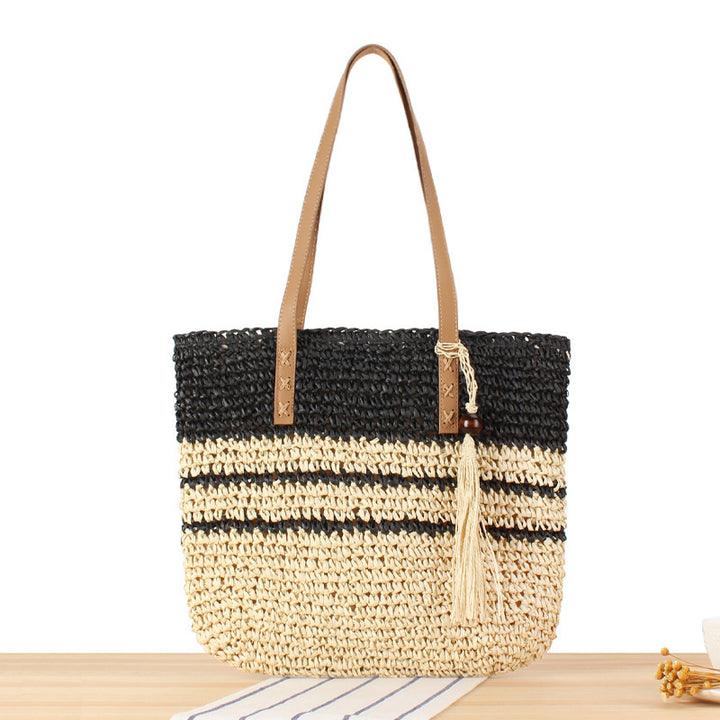 Handbag made of braided natural material with decorative tassel pendant Bowlift