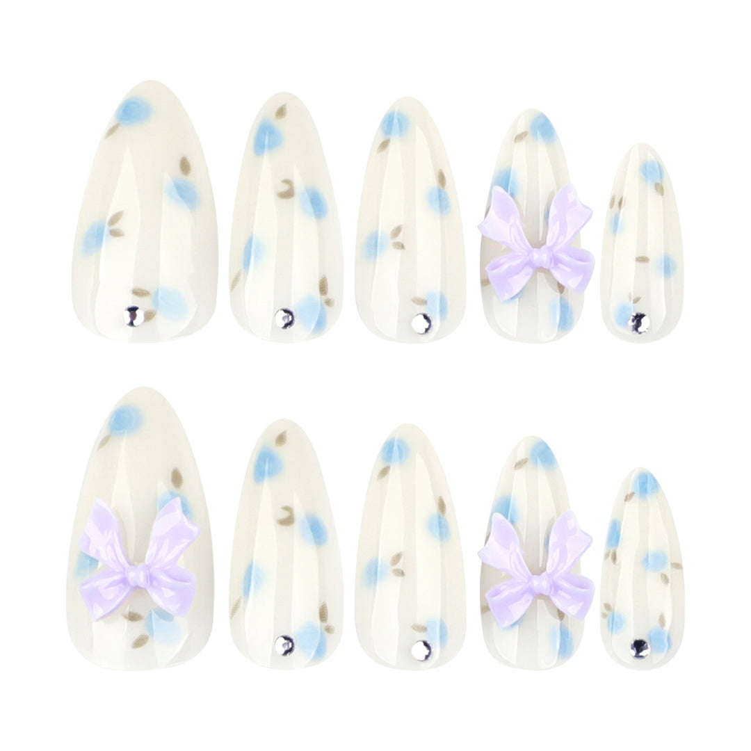 Artful stiletto nails with delicate flower patterns and glitter accents Bowlift