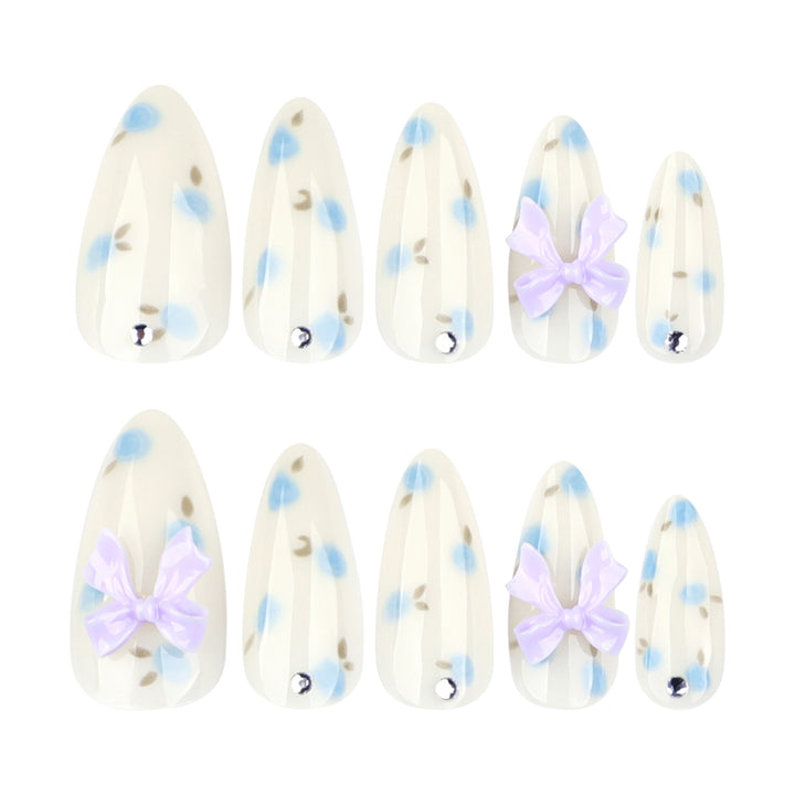 Artful stiletto nails with delicate flower patterns and glitter accents Bowlift
