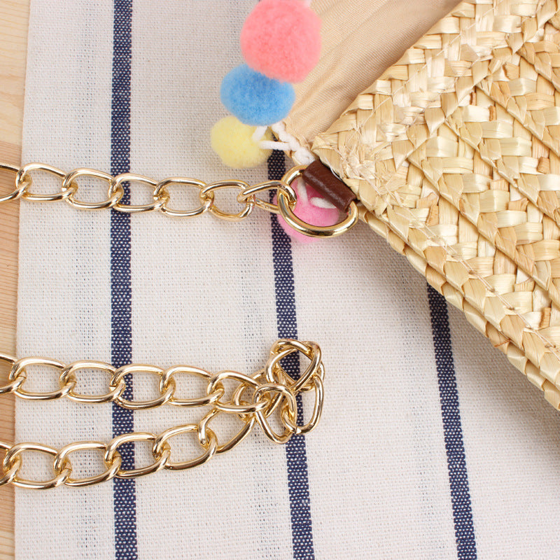 Clutch made of handwoven natural material with decorative pompons Bowlift