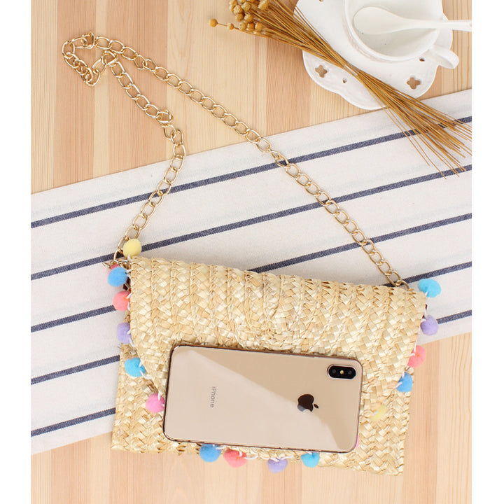 Clutch made of handwoven natural material with decorative pompons Bowlift
