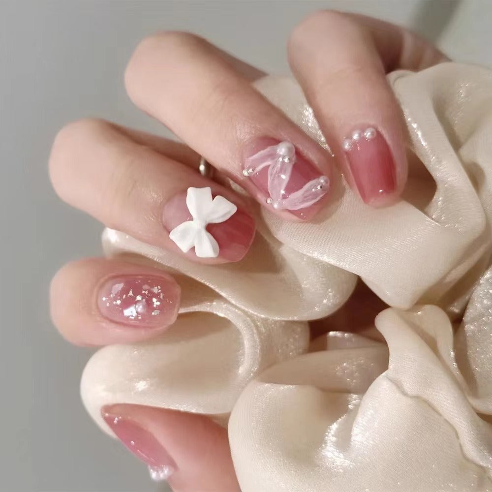 Glamorous nail art with pearl and bow accents Bowlift