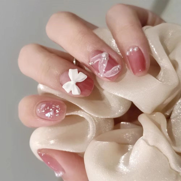 Glamorous nail art with pearl and bow accents Bowlift