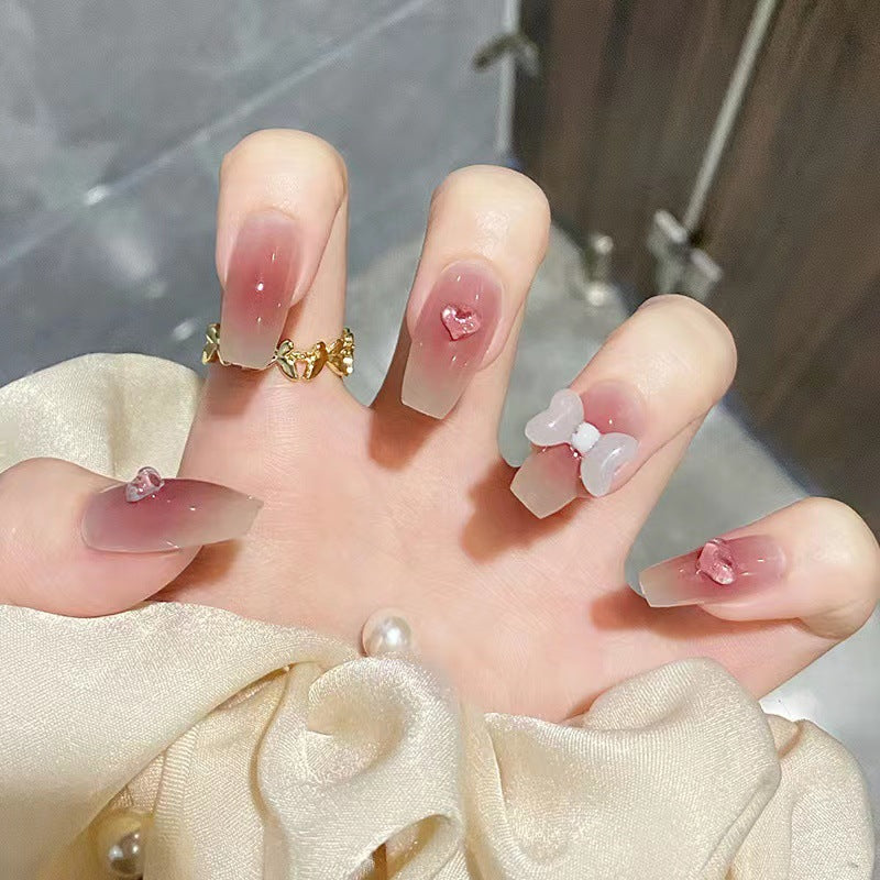 Artful acrylic nails with heart and bow design Bowlift
