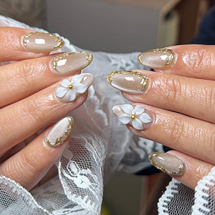 Acrylic nail set with elegant gold embellishments and floral accent Bowlift
