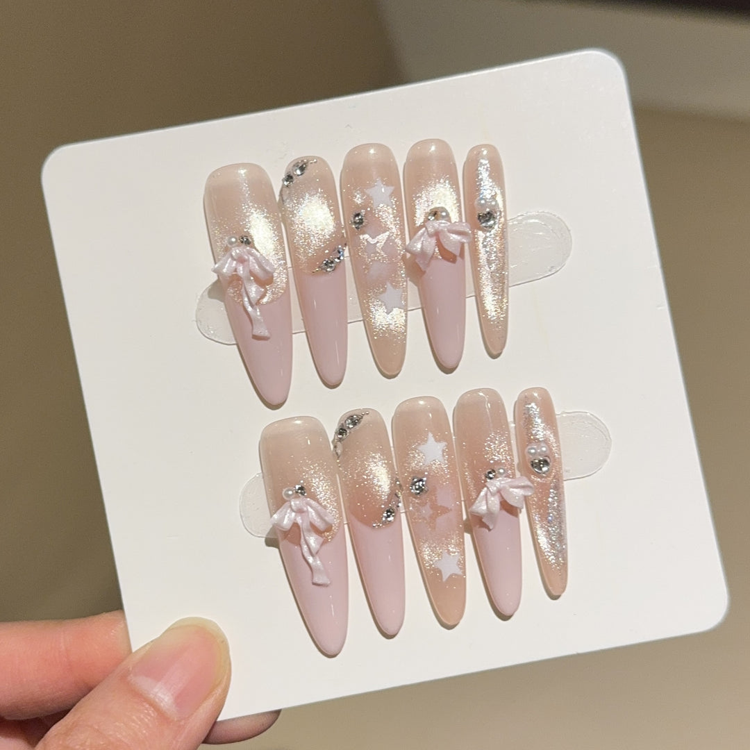 Artificial nail tips with glamorous glitter and bow details Bowlift
