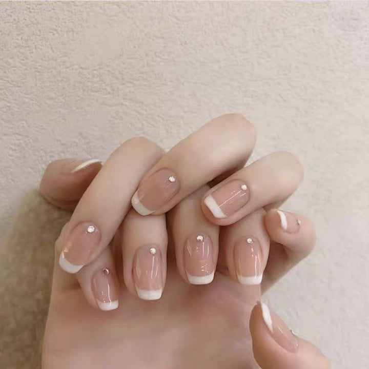 Artificial nails with elegant French tip and rhinestone accents Bowlift