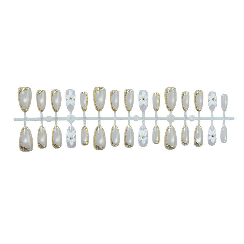 Acrylic nail set with elegant gold embellishments and floral accent Bowlift