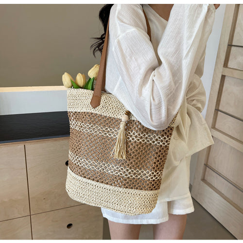 Handbag made of woven natural material with playful tassel detail Bowlift