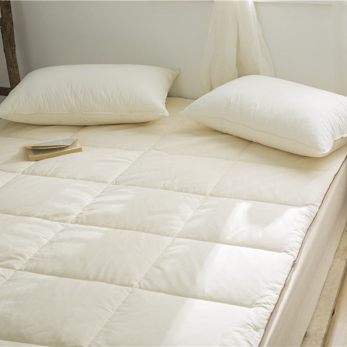 Quilted mattress topper as a soft overlay with non-slip corner bands
