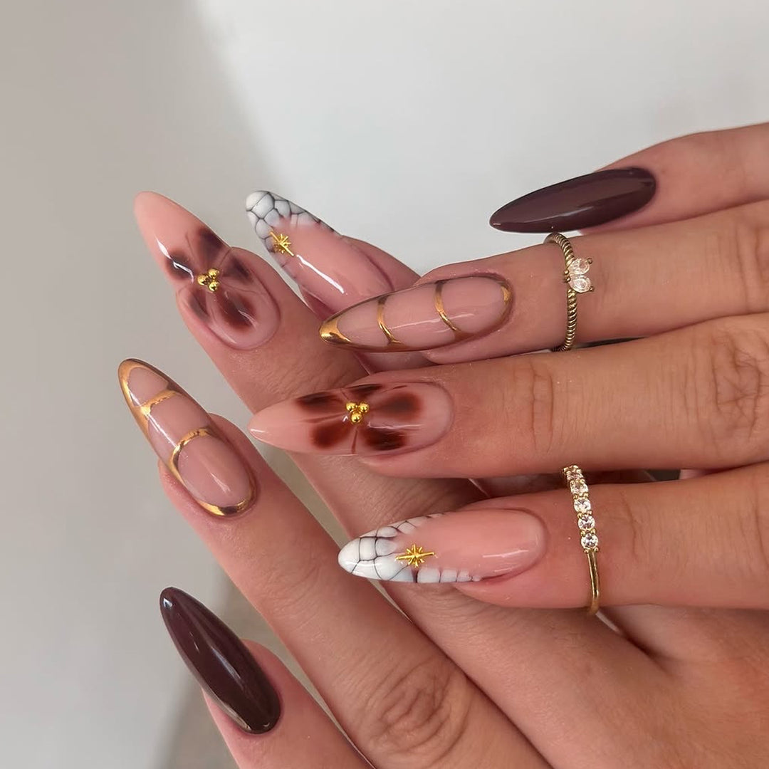 Artful Stiletto nails with gold accents and decorative floral designs Bowlift