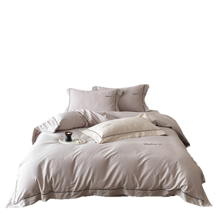 Elegant cotton satin bedding set with fine piped trim and monogram embroidery
