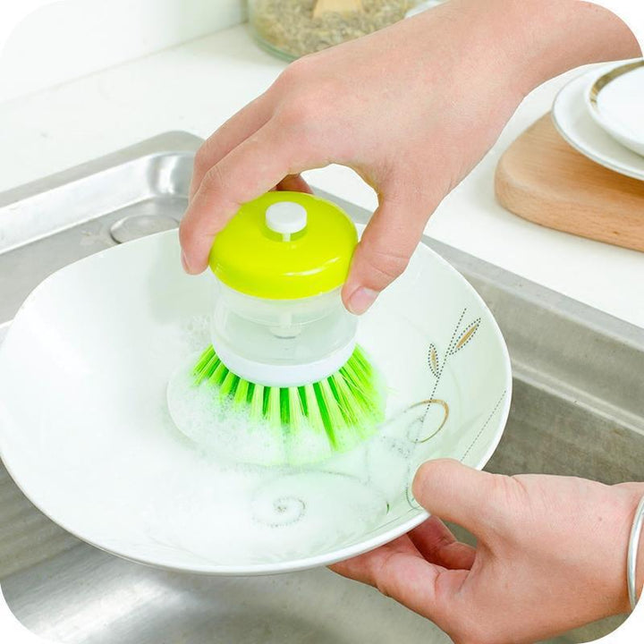 Dish brush with soap dispenser for pressing